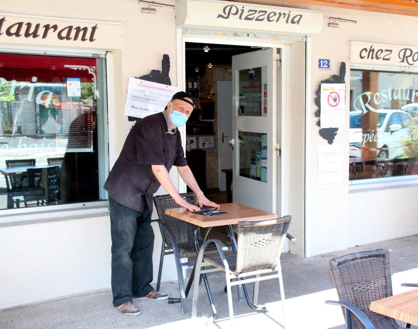 Roberto préparant la terrasse devant son restaurant à Ternay